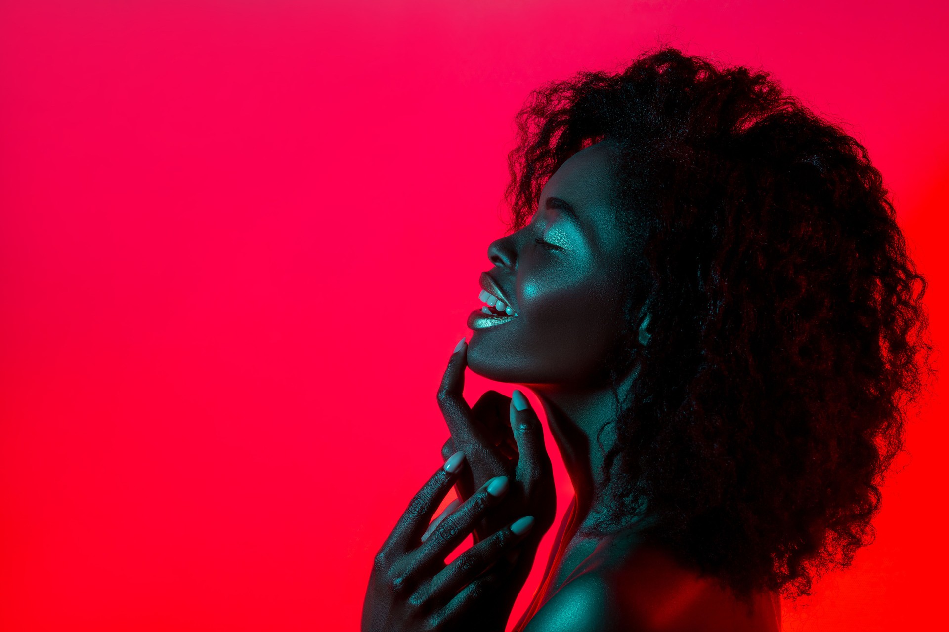 High Fashion model woman in colorful bright lights posing in studio